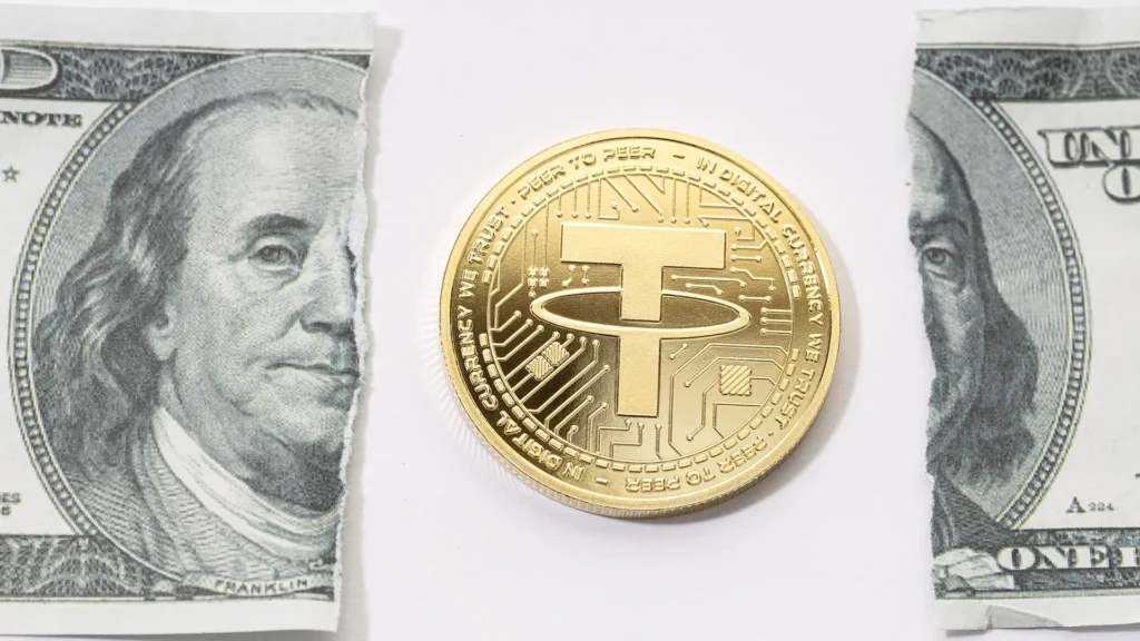 A gold coin placed in the middle of a ripped one-dollar bill.