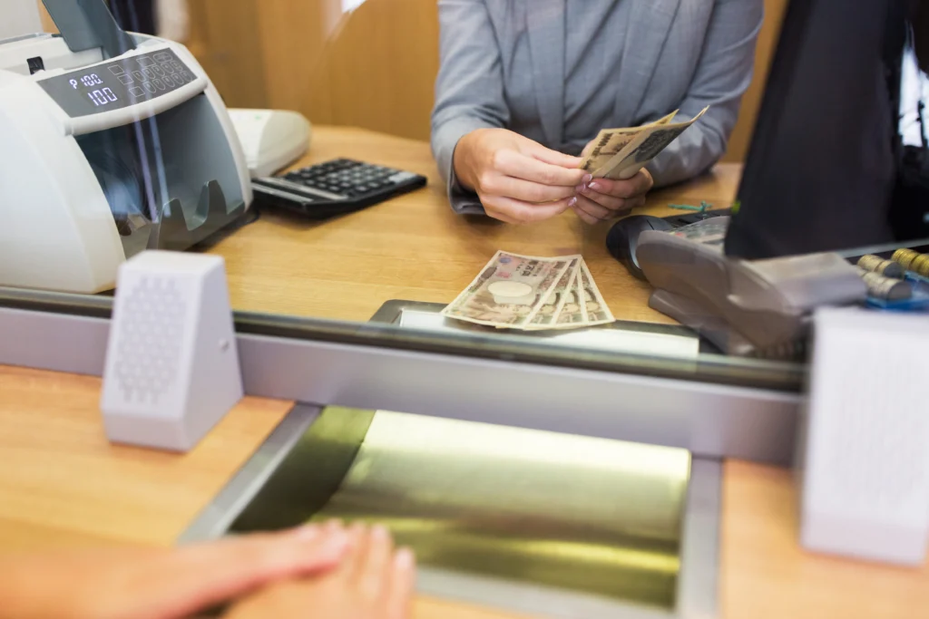 Clerk counting cash money at bank office.
