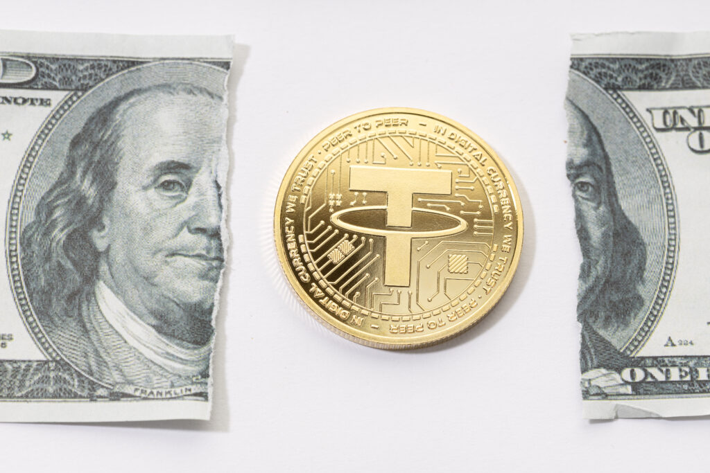 A gold coin placed in the middle of a ripped one-dollar bill.