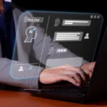 Individual using a laptop with a virtual interface, highlighting developments in visual agentic AI tools and their market impact