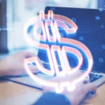 Hands type on a laptop with a large, glowing digital dollar sign overlay. The image conveys themes of online finance and technology.